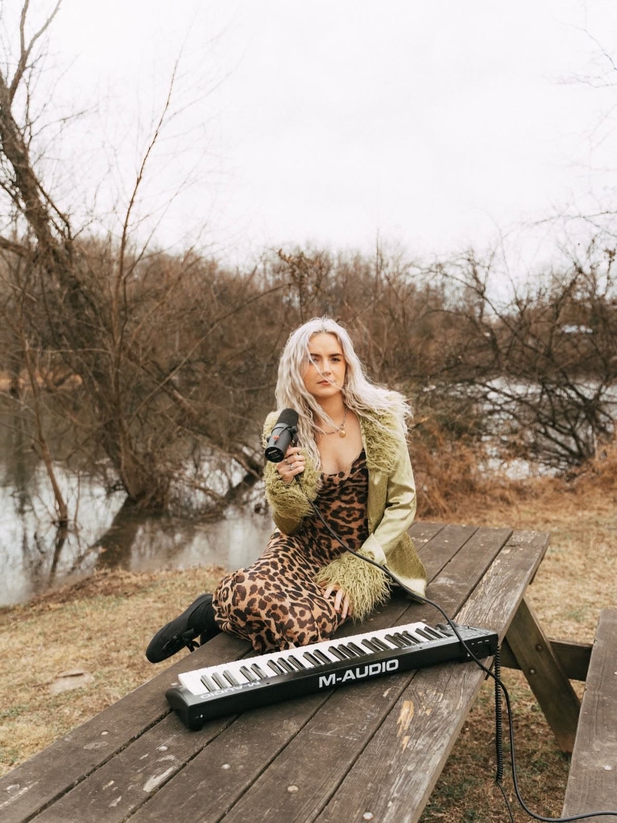 Felicity singing outdoors in a green coat with a keyboard