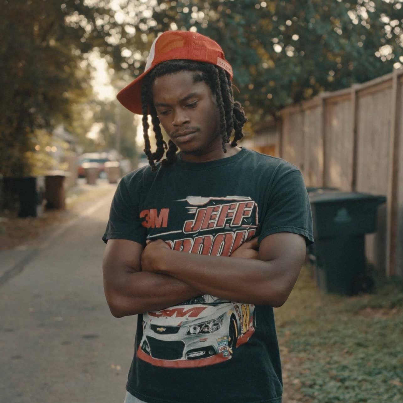 Jyou in a red cap with arms crossed on an East Nashville street